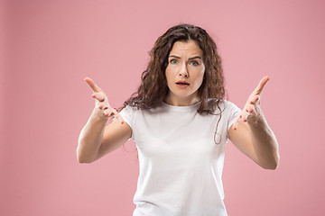 Image showing Beautiful female half-length portrait isolated on pink studio backgroud. The young emotional surprised woman