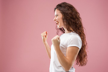 Image showing The happy business woman standing and smiling against pink background.