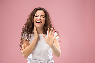 Image showing The happy business woman standing and smiling against pink background.