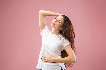 Image showing The happy business woman standing and smiling against pink background.