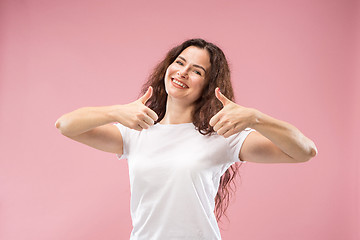 Image showing The happy business woman standing and smiling against pink background.