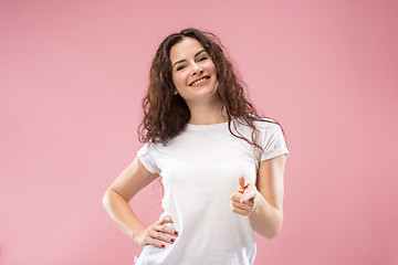 Image showing The happy business woman standing and smiling against pink background.