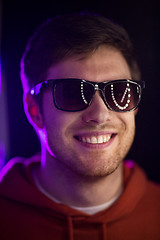 Image showing man in sunglasses over ultra violet neon lights