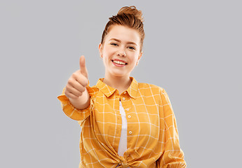 Image showing smiling red haired teenage girl showing thumbs up