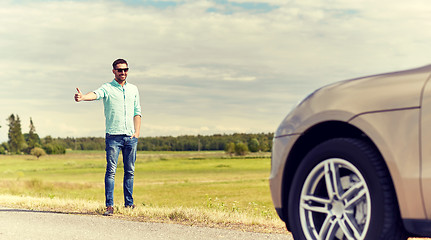 Image showing man hitchhiking and stopping car at countryside