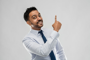 Image showing indian businessman pointing finger at something