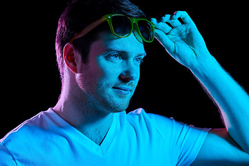 Image showing man in sunglasses over ultra violet neon lights