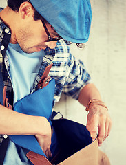 Image showing close up of hipster man looking into his bag