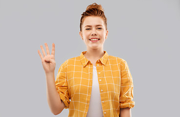 Image showing red haired teenage girl showing four fingers