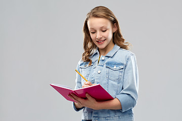 Image showing teenage student girl writing to diary or notebook