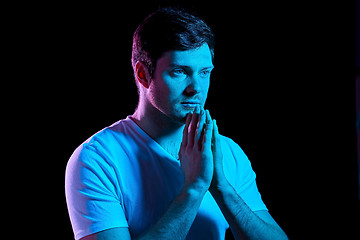 Image showing man praying god over ultra violet neon lights