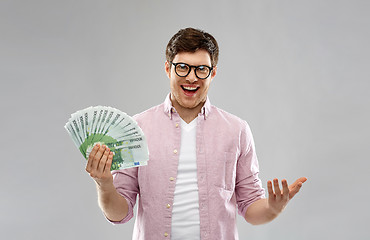 Image showing happy young man in glasses with fan of euro money