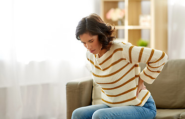 Image showing unhappy woman suffering from backache at home