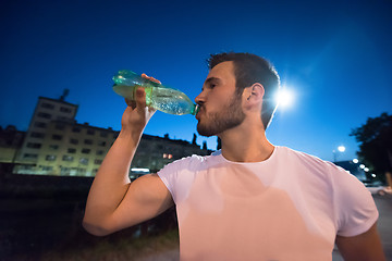 Image showing man drinking water after running session