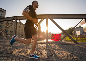 Image showing man jogging across the bridge at sunny morning