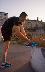 Image showing man tying running shoes laces