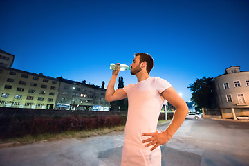 Image showing man drinking water after running session