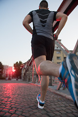 Image showing man jogging across the bridge at sunny morning