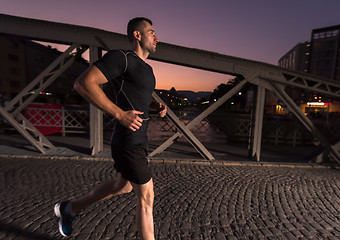 Image showing man jogging across the bridge in the city