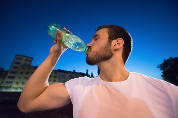 Image showing man drinking water after running session