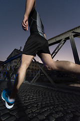 Image showing man jogging across the bridge in the city