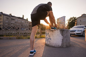 Image showing man tying running shoes laces