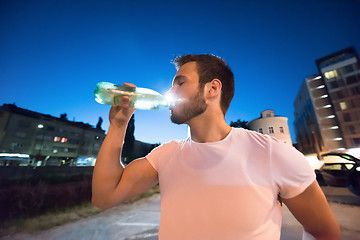 Image showing man drinking water after running session