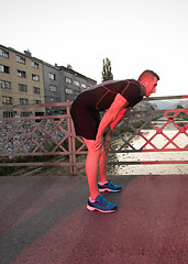 Image showing man jogging across the bridge at sunny morning