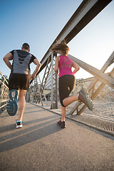 Image showing young couple jogging across the bridge in the city