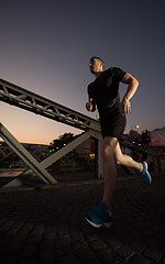 Image showing man jogging across the bridge in the city