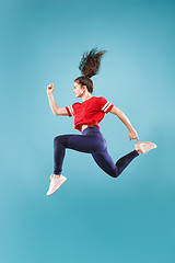 Image showing Freedom in moving. Pretty young woman jumping against pink background