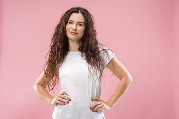 Image showing The happy business woman standing and smiling against pink background.