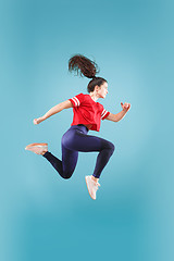 Image showing Freedom in moving. Pretty young woman jumping against pink background