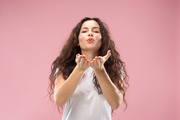 Image showing The happy business woman standing and smiling against pink background.