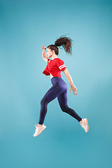 Image showing Freedom in moving. Pretty young woman jumping against pink background