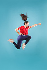 Image showing Freedom in moving. Pretty young woman jumping against pink background