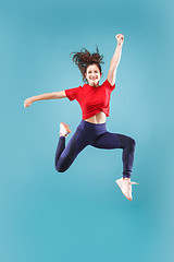 Image showing Freedom in moving. Pretty young woman jumping against pink background