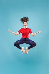 Image showing Freedom in moving. Pretty young woman jumping against pink background