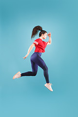 Image showing Freedom in moving. Pretty young woman jumping against pink background