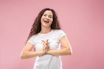 Image showing The happy business woman standing and smiling against pink background.