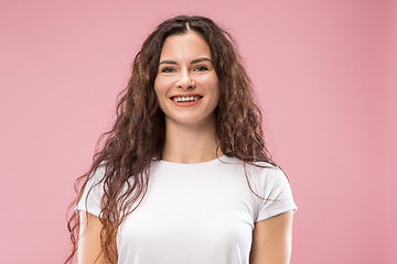 Image showing The happy business woman standing and smiling against pink background.