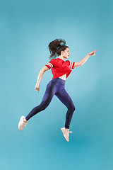 Image showing Freedom in moving. Pretty young woman jumping against pink background