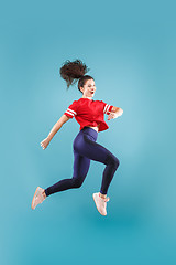 Image showing Freedom in moving. Pretty young woman jumping against pink background