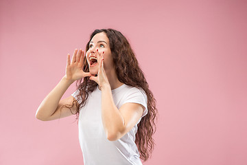 Image showing Isolated on pink young casual woman shouting at studio