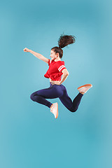 Image showing Freedom in moving. Pretty young woman jumping against pink background