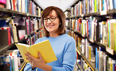 Image showing portrait of senior woman in glasses reading book