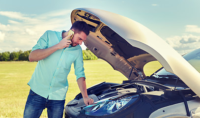 Image showing man with broken car calling on smartphone
