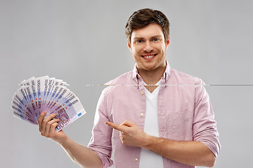 Image showing smiling young man showing fan of euro money