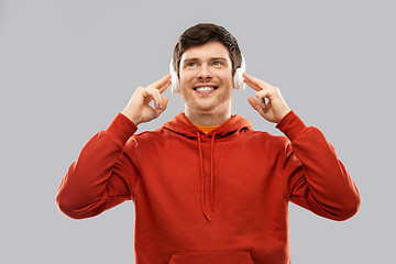 Image showing happy young man in headphones and red hoodie