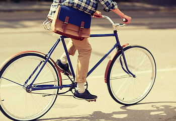 Image showing young hipster man with bag riding fixed gear bike